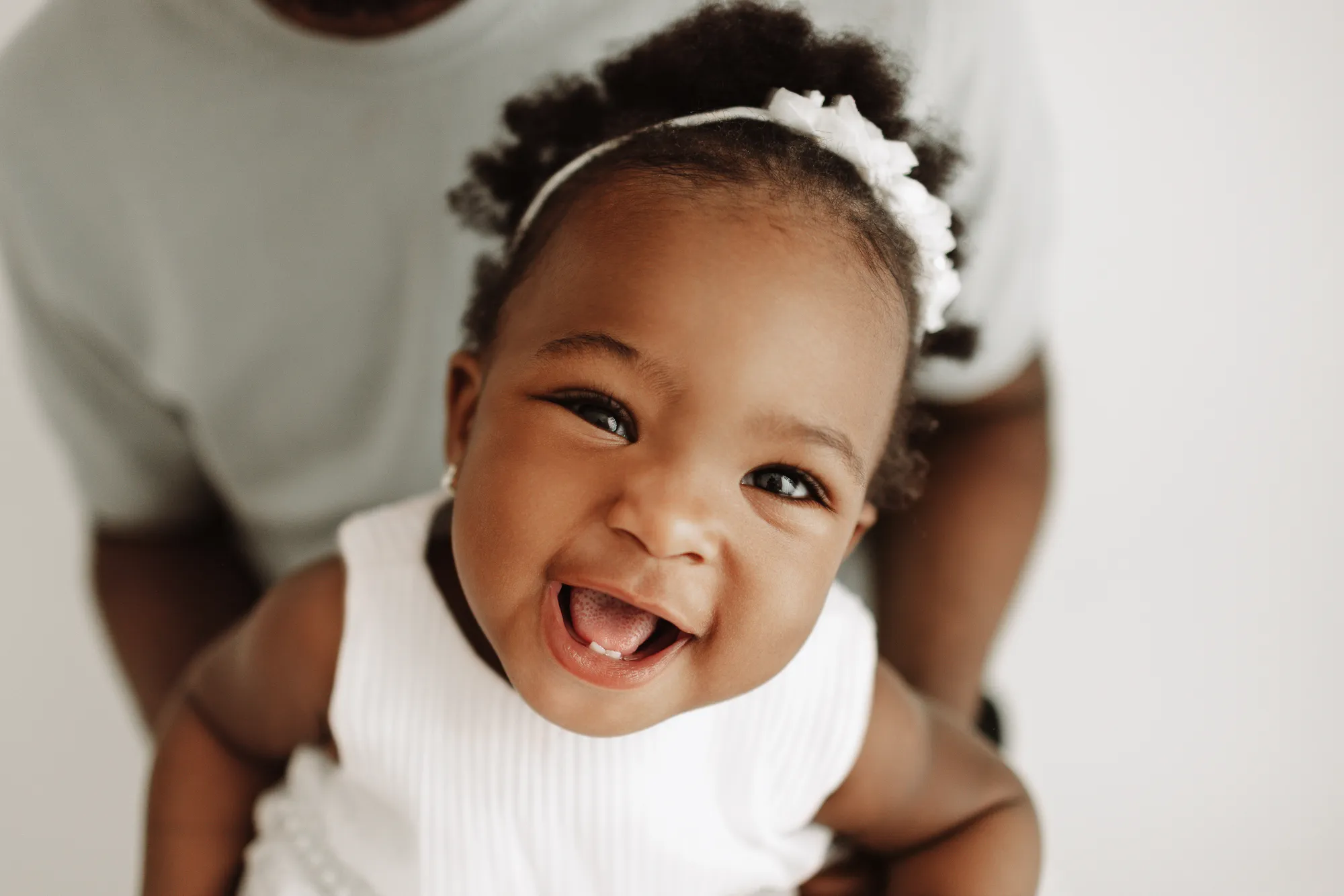 Close-up of the birthday girl laughing, held by her dad