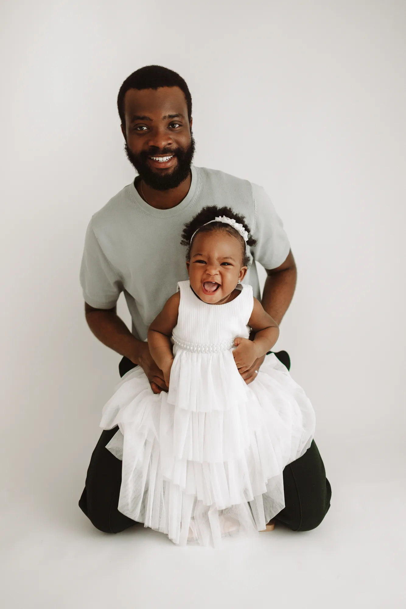 Dad kneeling behind his daughter in her white tulle dress