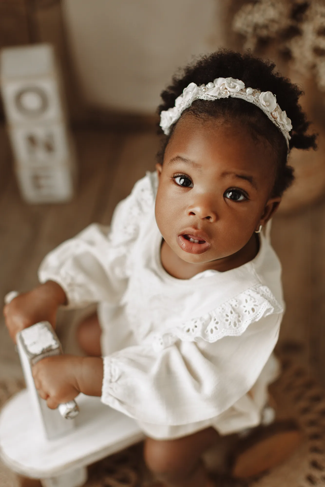 Close-up of the birthday girl with a white flower headband on a rustic set