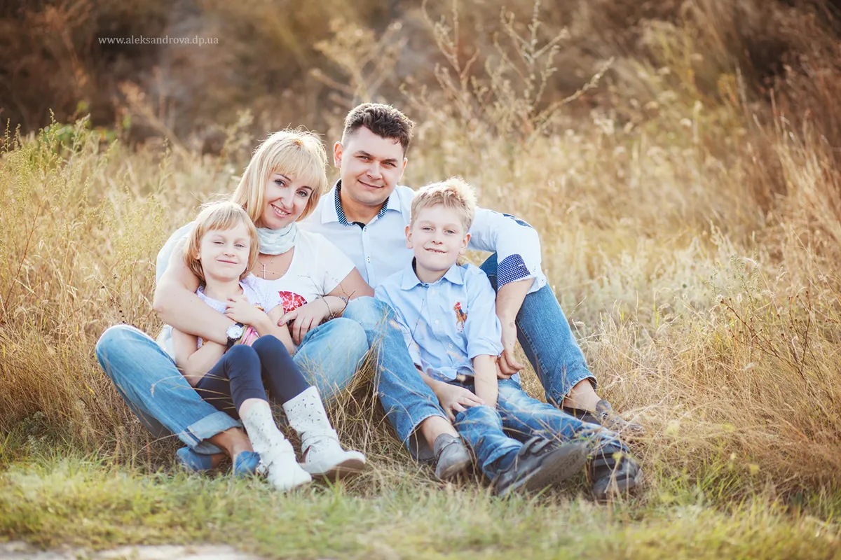 Parents and children sitting together in autumn grass